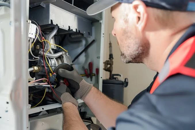Technician checking the components of an open heating system